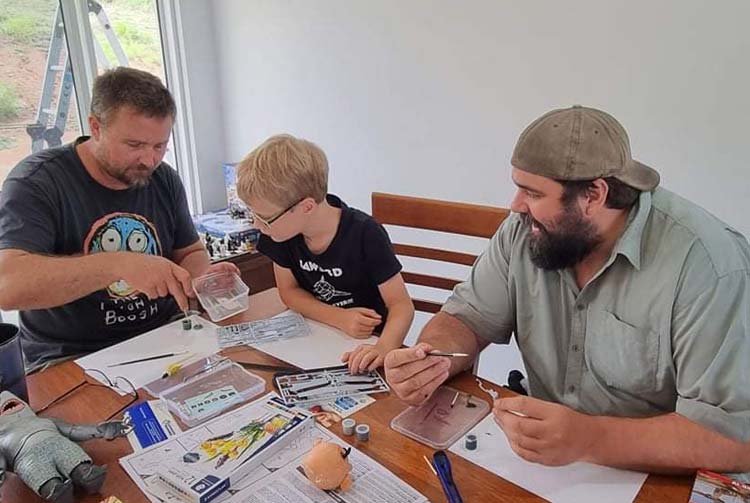 Assisting a youth make a model plane with his Dad
